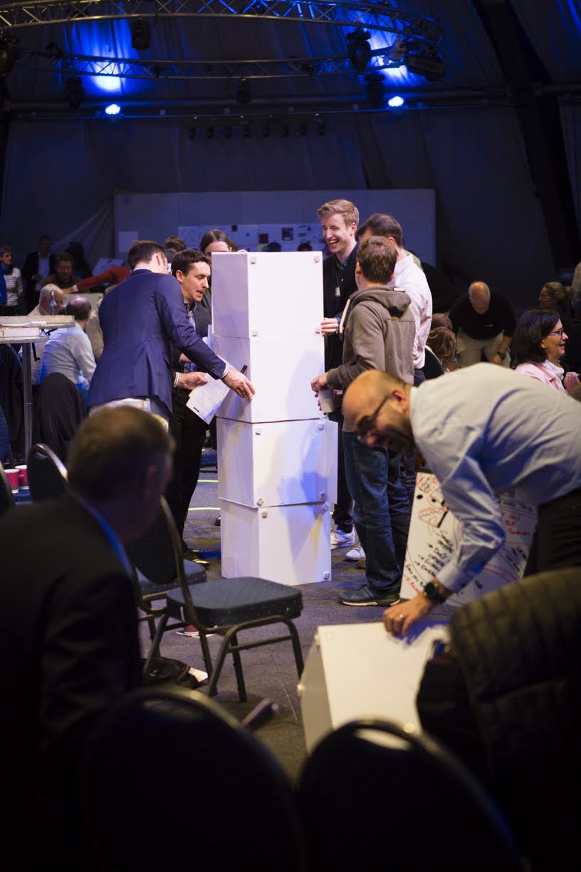 Participants lors d’un workshop collaboratif utilisant les cubes Tetrix recouverts de panneaux Velleda comme supports d’écriture et de co-création.